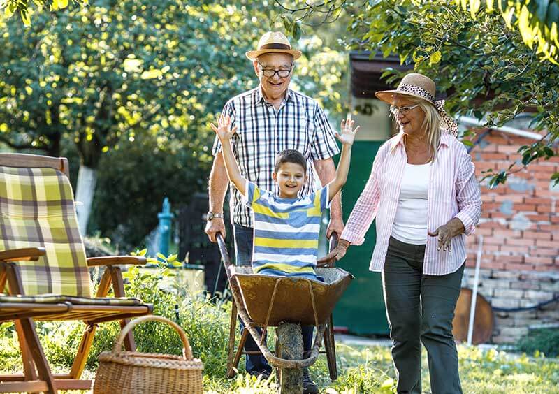 Older couple hanging out with grandson in the garden