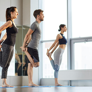 Three people doing bar exercises